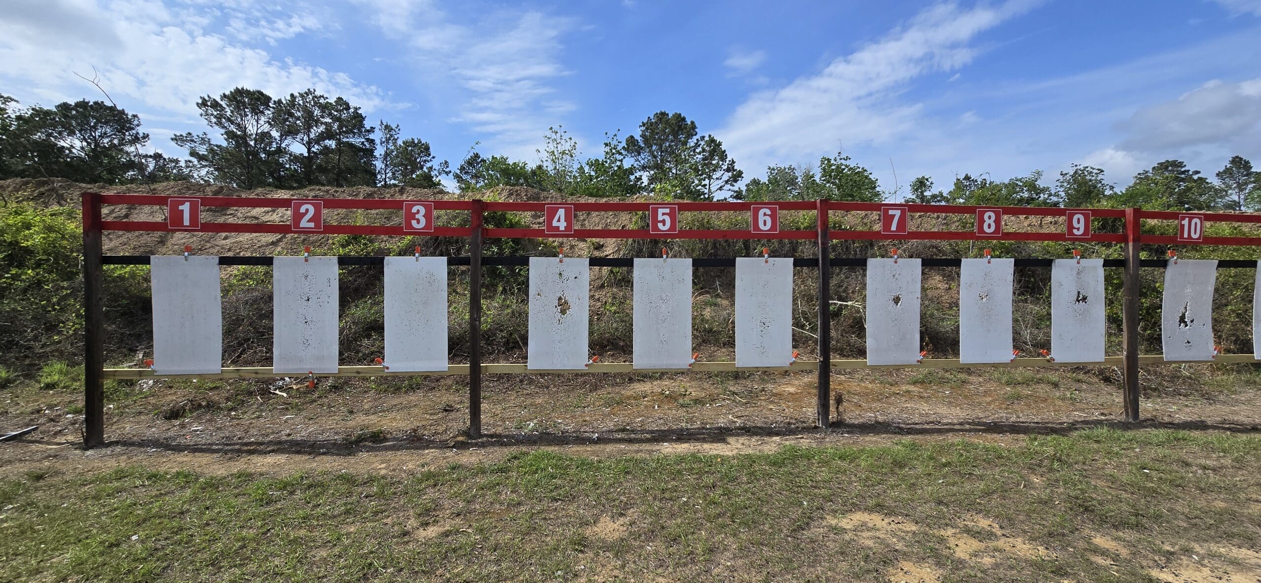 A row of ten white shooting targets numbered 1 to 10.